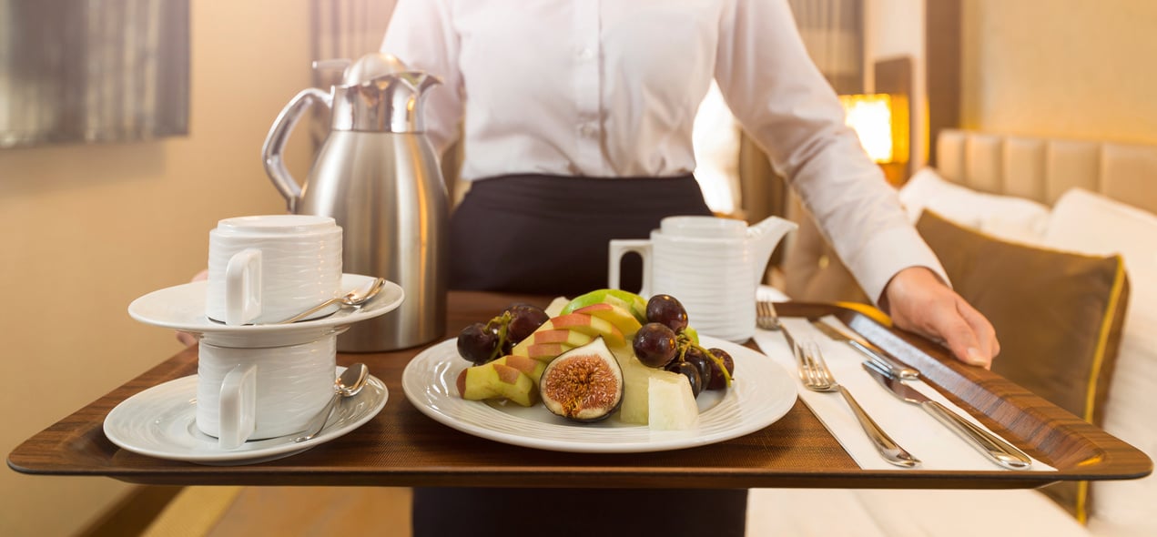 Room service hotel staff holding food platter